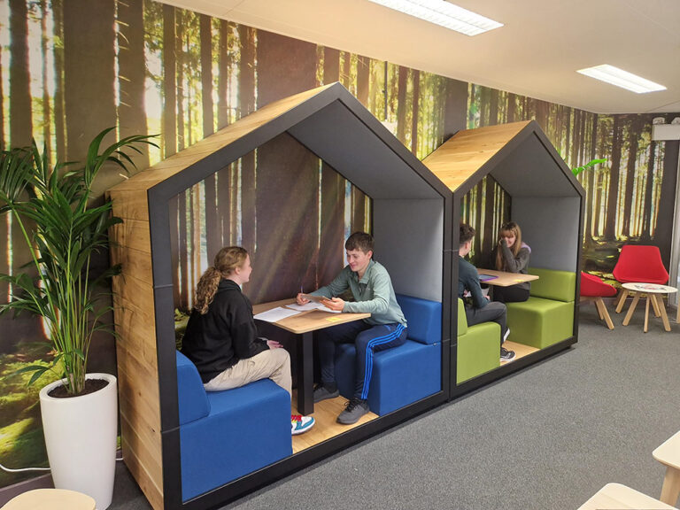 Image of 4 students sitting in wooden tree-house style booths